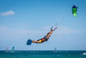 Man,Kitesurfer,Athlete,Jumping,While,Performing,Kite-surfing